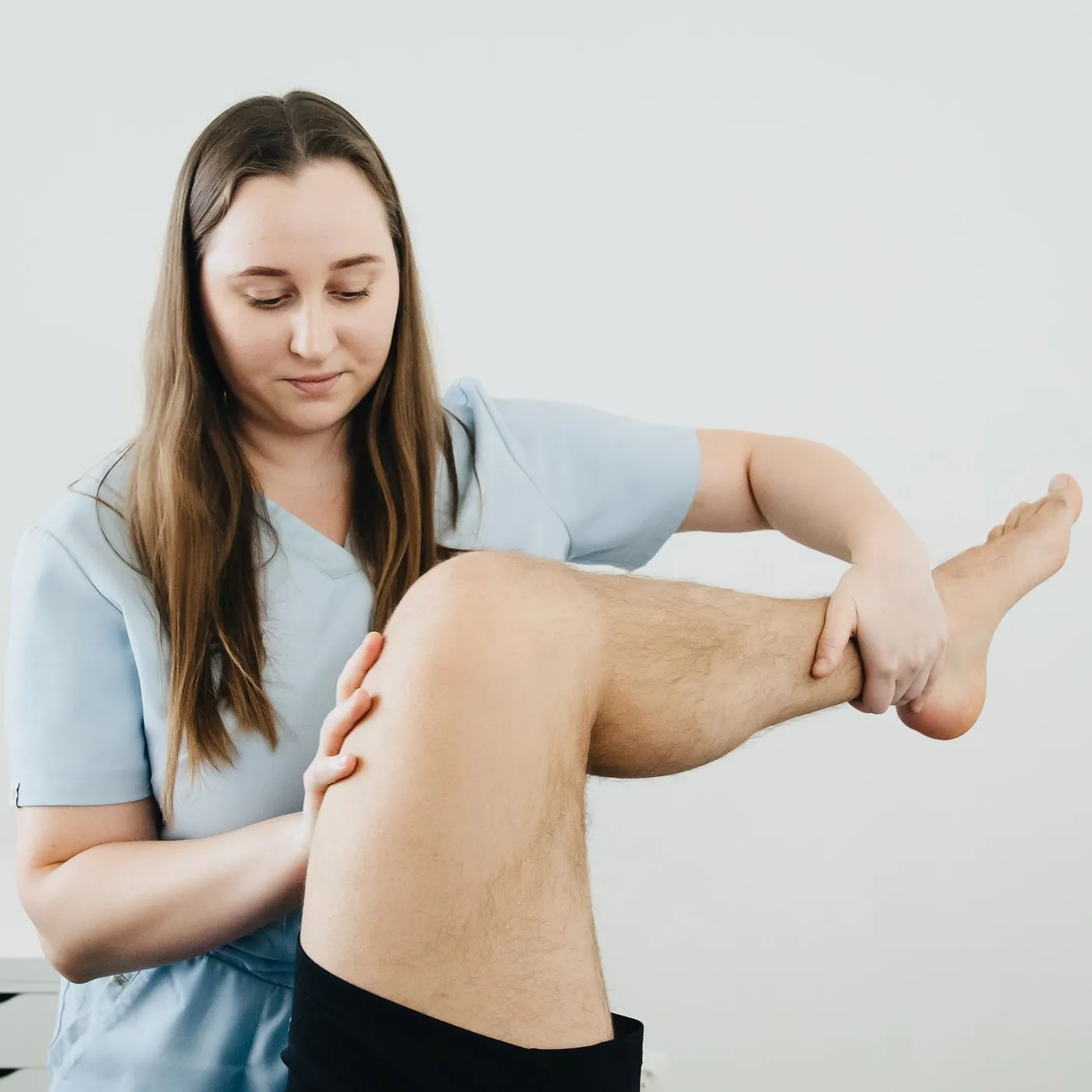 Les mains d’une kinésithérapeute pendant une séance de rééducation